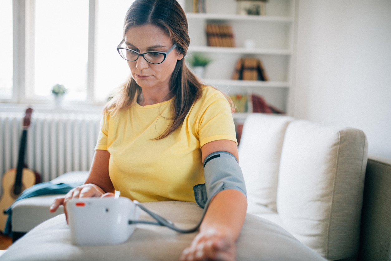 Mujer midiéndose la presión arterial en casa
